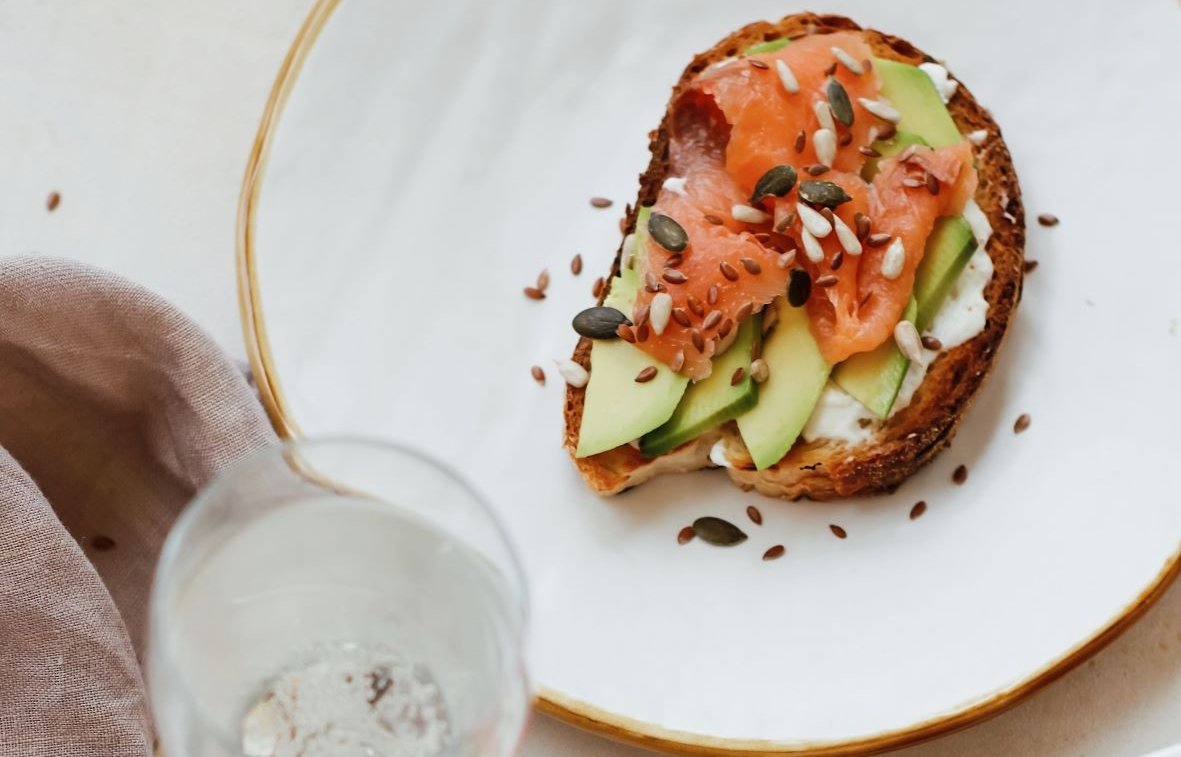 Zu sehen ein Teller mit ein belegten Lachs-Avocado Brot.