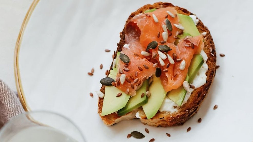 Zu sehen ein Teller mit ein belegten Lachs-Avocado Brot.