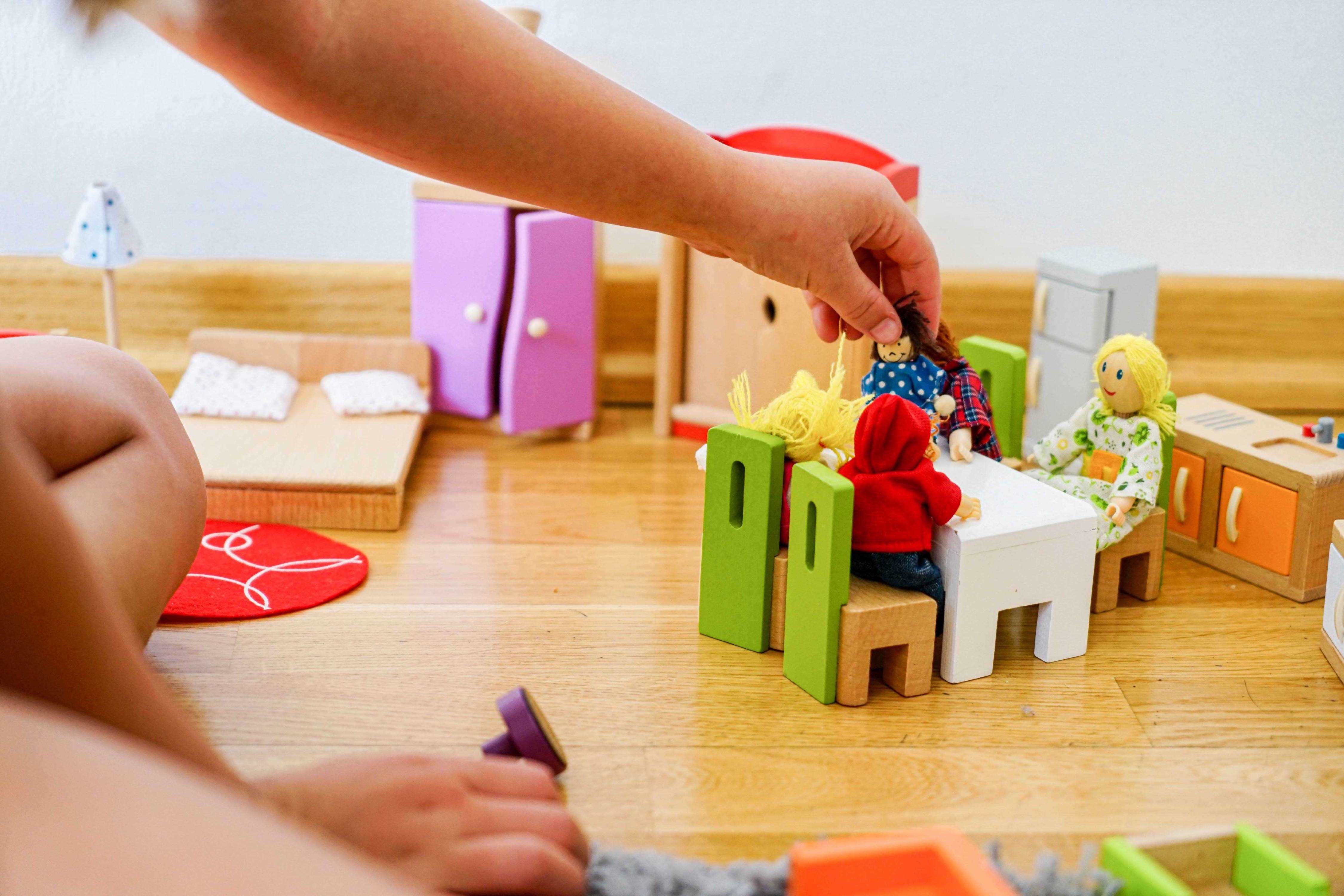 Hände eines Kindes, das mit Playmobil - Figuren spielt